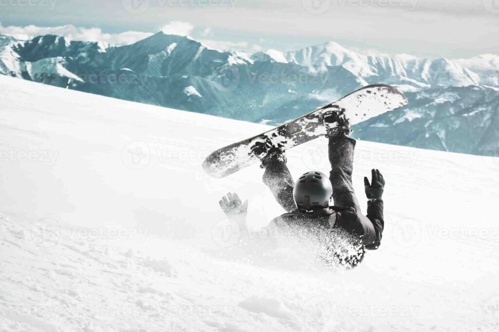 snowboarder fall down on back with snow splashes on snowy off piste ski slope and old chair lift at background caucasus mountains in sunny winter day black and white toned image photo 1